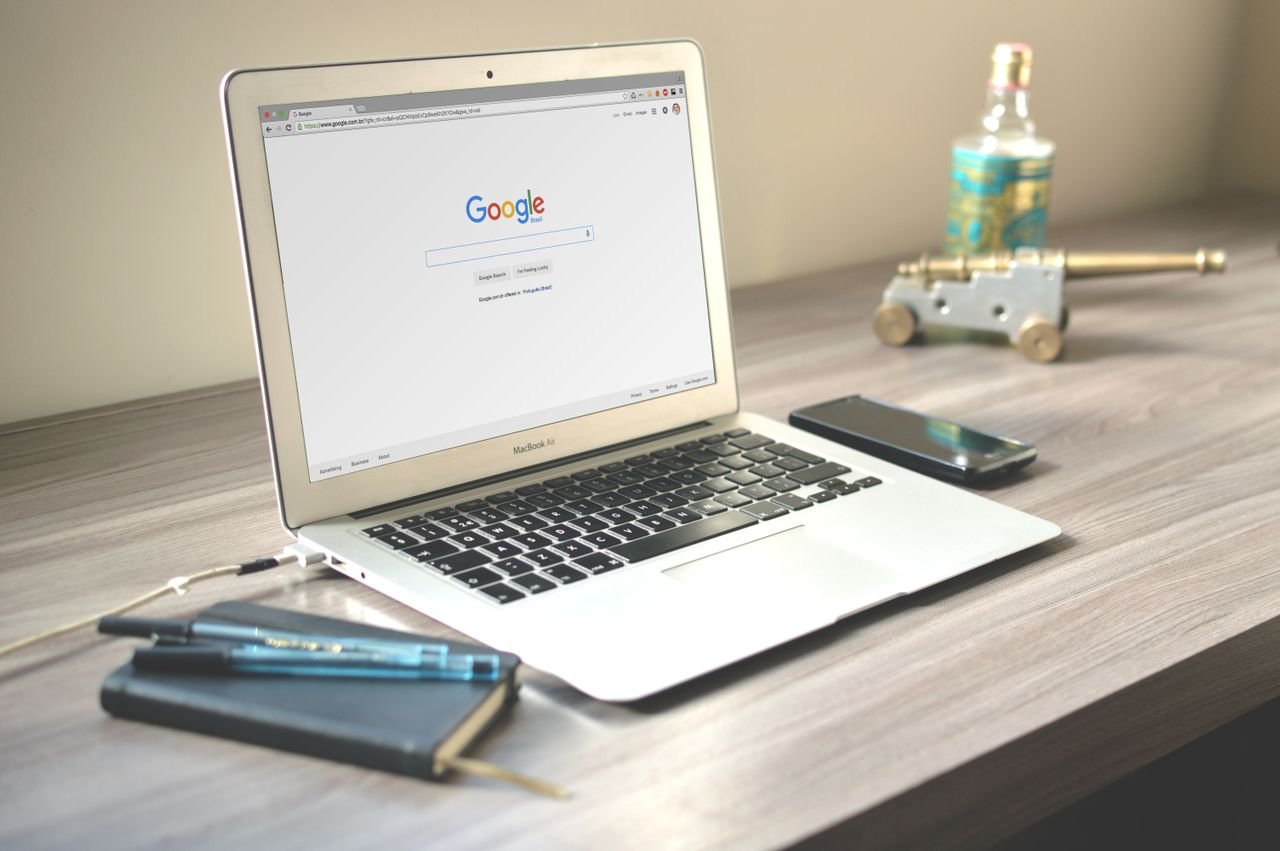 “Laptop workspace with Google search, notebook and pencil for planning a digital product business”