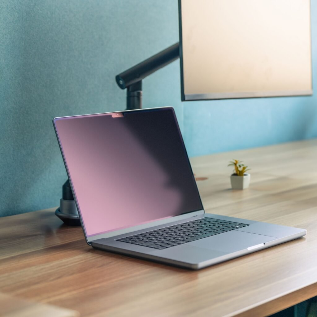 laptop on a desk with an adjustable stand and desk light