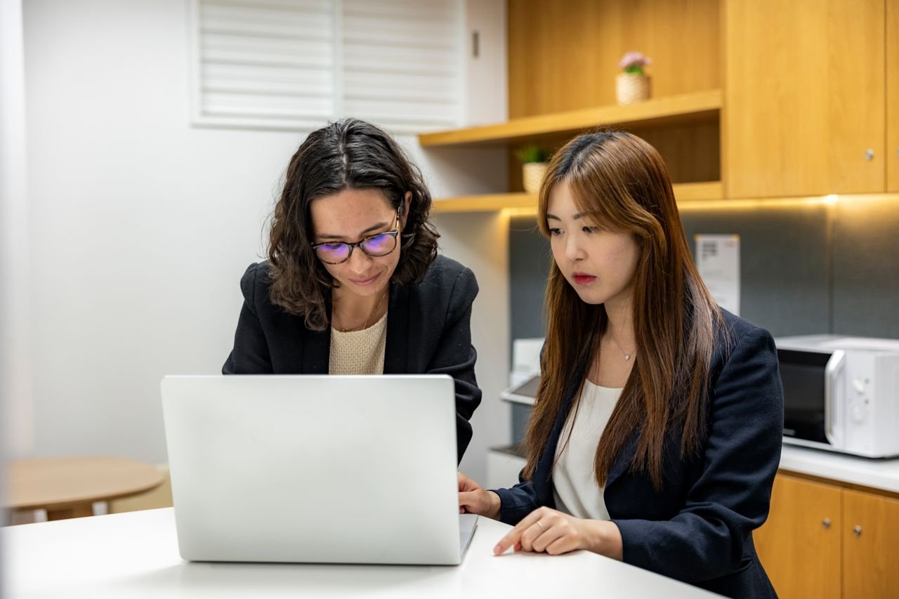Two women working together on a laptop in a small business office