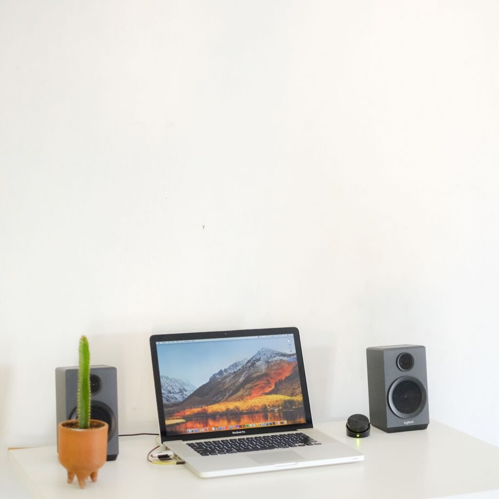 computer speakers beside a desktop monitor and laptop